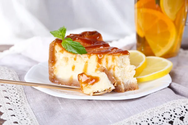 Pastel de queso en plato y té de hierbas en servilleta sobre fondo de cortina — Foto de Stock