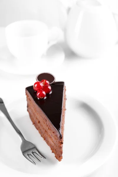 Delicioso bolo de chocolate na placa na mesa no fundo claro — Fotografia de Stock