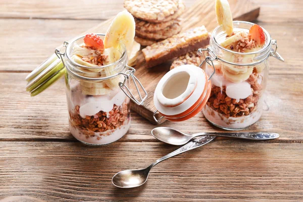 Postre en capas saludables con muesli y bayas en la mesa —  Fotos de Stock