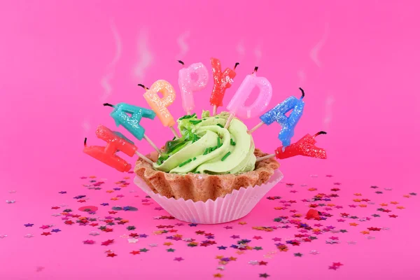Doğum günü mumları üzerinde pembe bir arka plan ile pasta — Stok fotoğraf