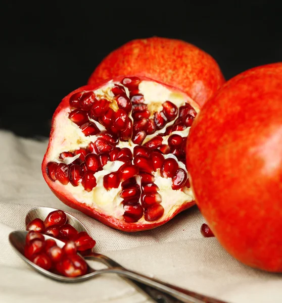 Saftige reife Granatäpfel auf dunklem Hintergrund — Stockfoto