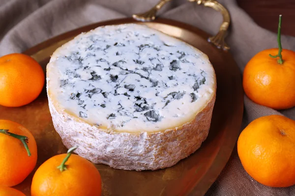 Blue cheese with oranges on metal tray on burlap cloth and wooden table background — Stock Photo, Image