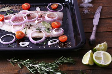 Baharatlar ve sebzeler firepan ve ahşap masa arka plan ile Pangasius fileto