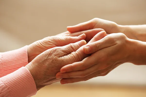 Old and young holding hands — Stock Photo, Image