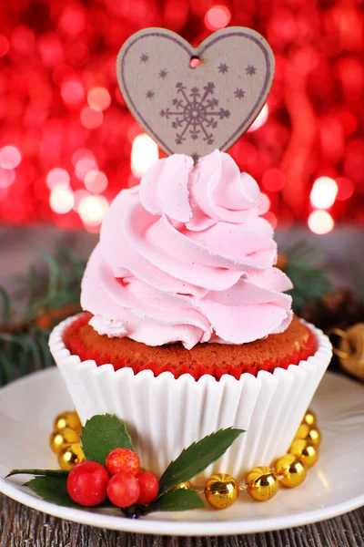 Copa-pastel con crema en platillo y decoración de Navidad en mesa de madera y brillo brillante fondo — Foto de Stock