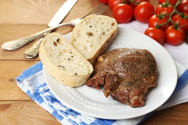 焼き肉と野菜のプレート、木製のテーブルの背景に — ストック写真