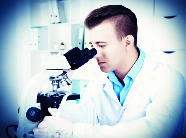开展科学研究在实验室里的年轻男研究员 — 图库照片