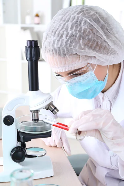 Cientista feminina usando microscópio em laboratório — Fotografia de Stock