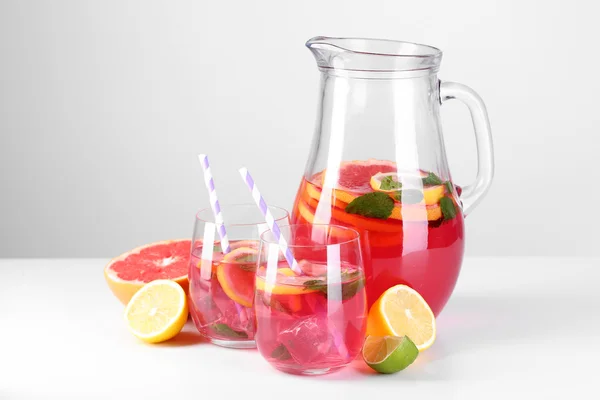 Limonada rosa en vasos y jarra aislada en blanco — Foto de Stock