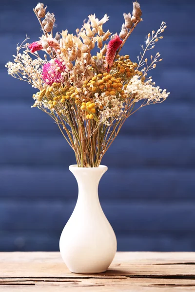 Szárított virágok vázában a színes csokor deszka háttér — Stock Fotó