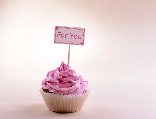 Läckra cupcake med inskription på bordet på beige bakgrund — Stockfoto