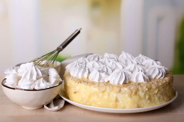 Tasty homemade meringue cake on wooden table, on light background — Stock Photo, Image