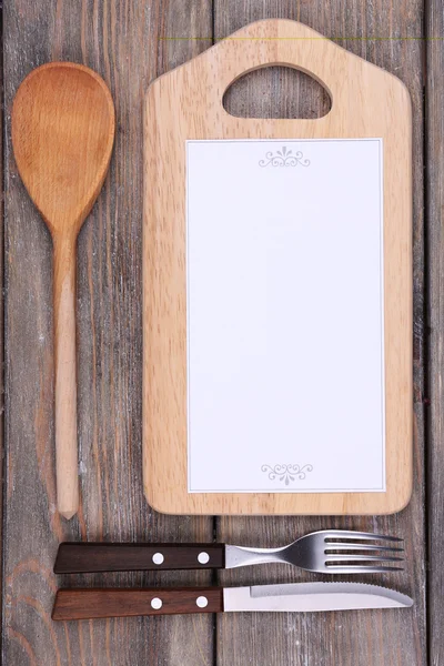 Cutting board with menu sheet of paper on rustic wooden planks background — Stock Photo, Image