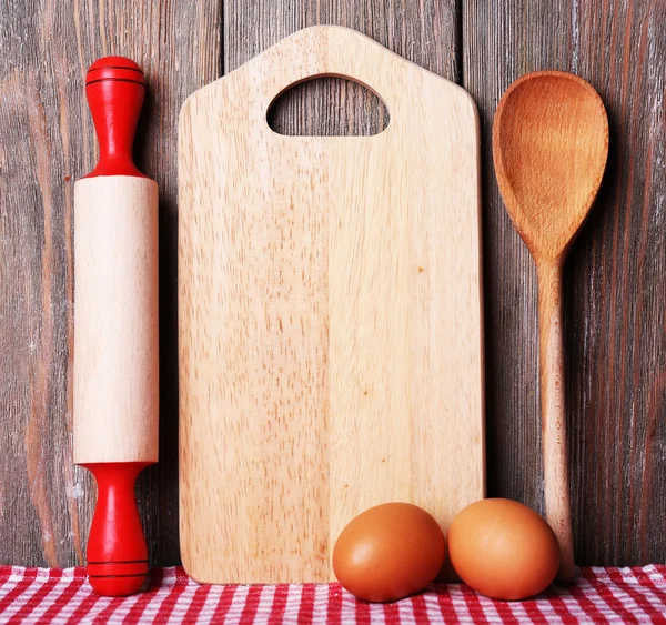 Planche à découper avec tomates cerises et laitue sur fond de planches de bois — Photo