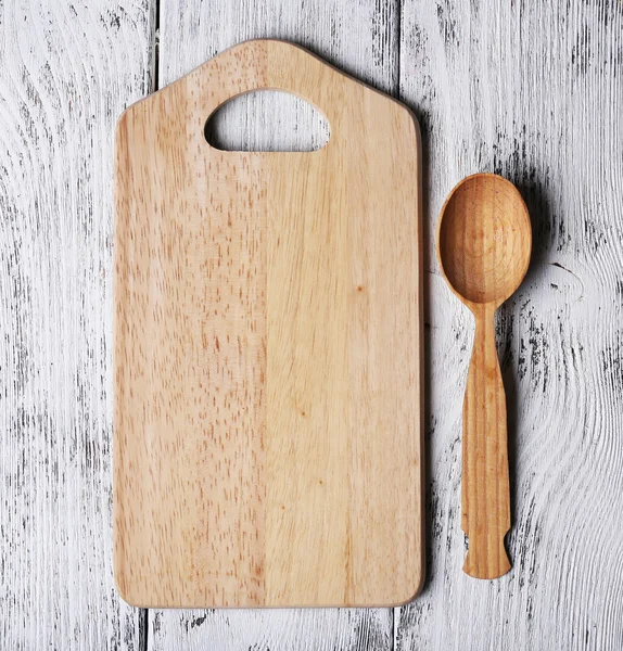 Cutting board on color wooden planks background — Stock Photo, Image
