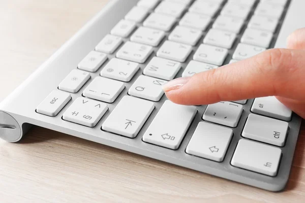 Mão feminina com teclado no fundo do desktop de madeira — Fotografia de Stock