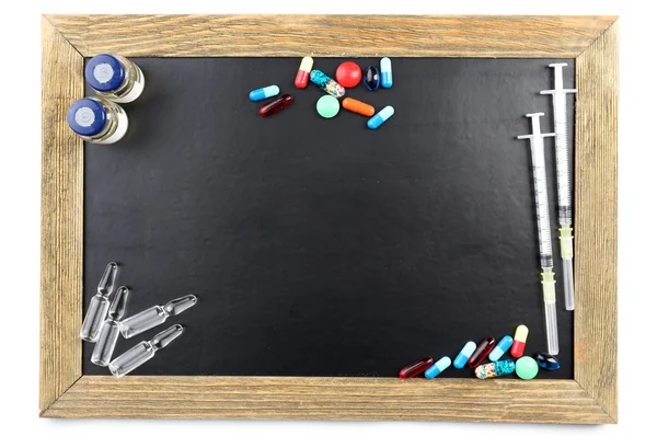 Tableau noir vierge avec des médicaments isolés sur fond blanc — Photo