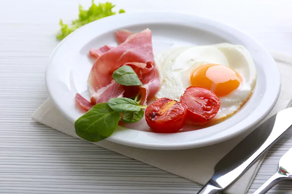 Tocino y huevos sobre fondo de mesa de madera de color — Foto de Stock