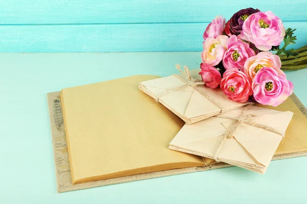 Gamla brev och bok med blommor på trä bakgrund — Stockfoto