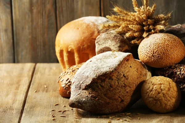 Different bread on table on wooden background — Stock Photo, Image