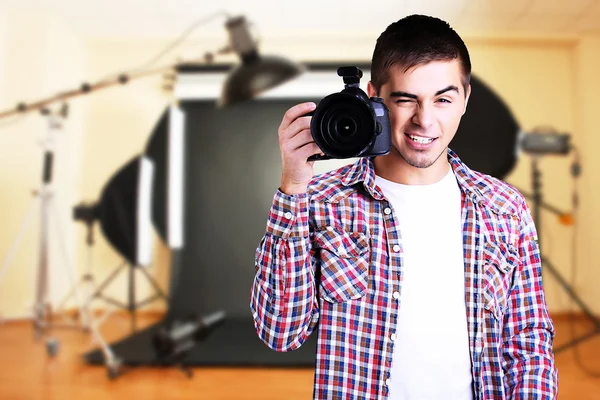 Tampan fotografer dengan kamera di studio foto — Stok Foto