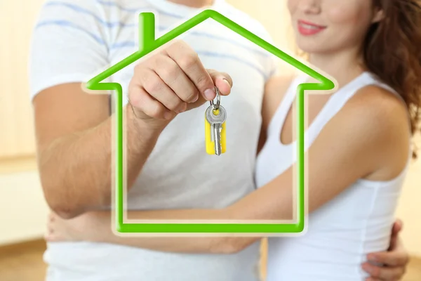 Loving couple with keys in drawing house — Stock Photo, Image