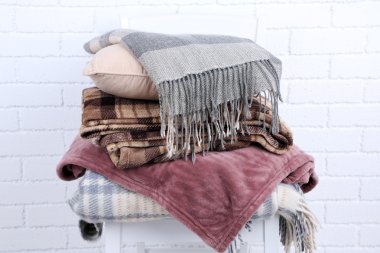 Sıcak ekoseler ve yastığın beyaz tuğla duvar arka plan üzerinde