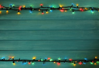 Ahşap plakalar arka plan üzerinde renkli Noel ışıkları