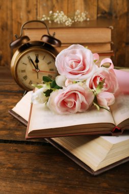 Ahşap zemin üzerine çiçek ve saat ile kitaplar