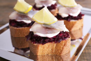 Çavdar tost ile ringa balığı ve pancar tepsi ahşap arka plan üzerinde