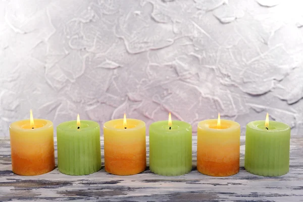 Hermosas velas en la mesa sobre fondo gris — Foto de Stock