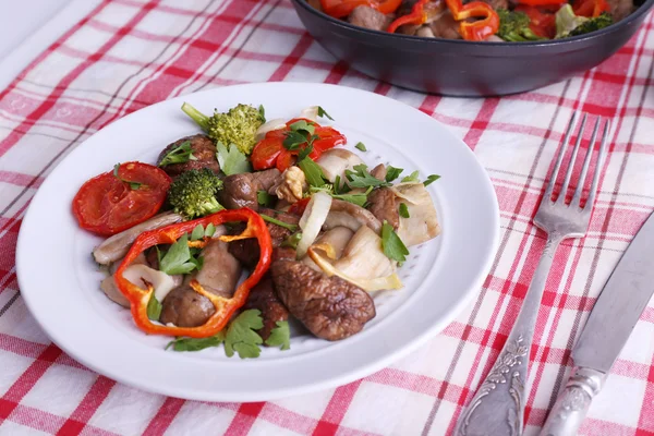 Champiñones silvestres estofados con verduras y especias en sartén y plato sobre mesa —  Fotos de Stock