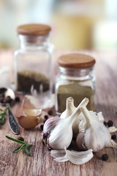 Rauwe knoflook en kruiden op houten tafel — Stockfoto