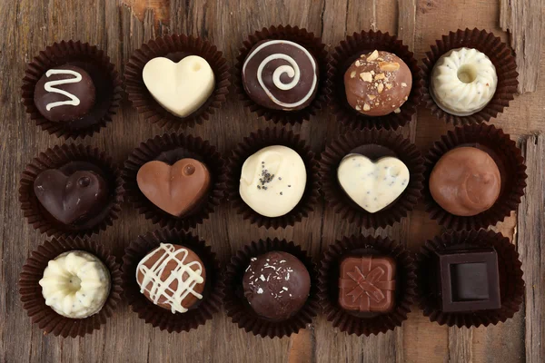 Delicious chocolate candies on wooden background — Stock Photo, Image