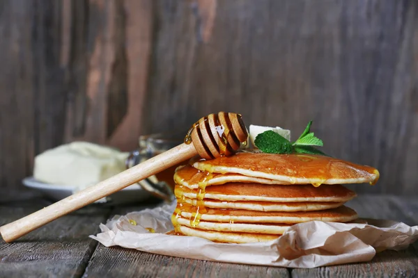 Montón de panqueques con miel y mantequilla sobre fondo rústico de madera —  Fotos de Stock