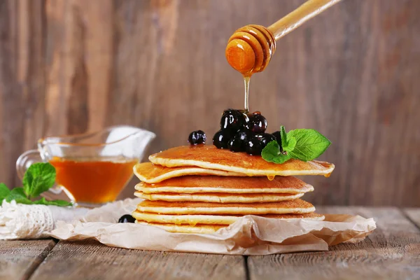 Pila di frittelle con menta e bacche su sfondo in legno rustico — Foto Stock