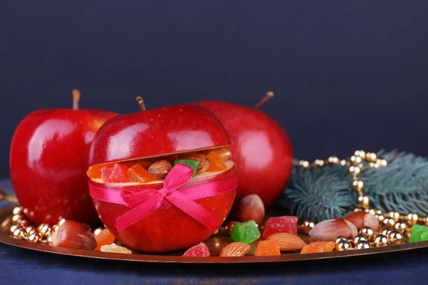 Christmas red apples stuffed with dried fruits on metal tray on color wooden table and dark background — Stock Photo, Image