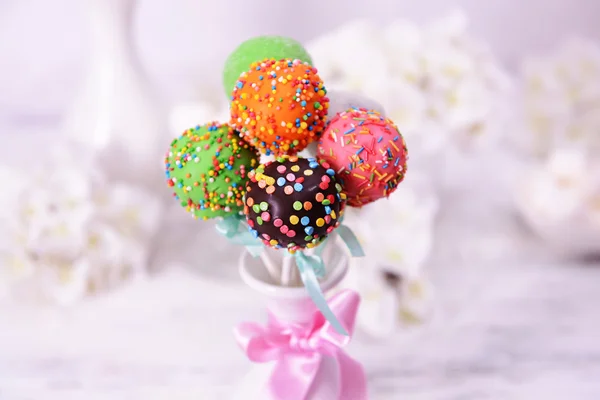 Sweet cake pops in vase on table on light background — Stock Photo, Image