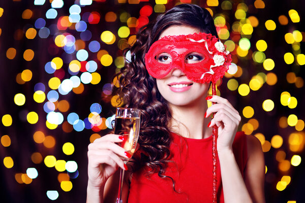 Beautiful girl with masquerade mask and glass of champagne on bright background