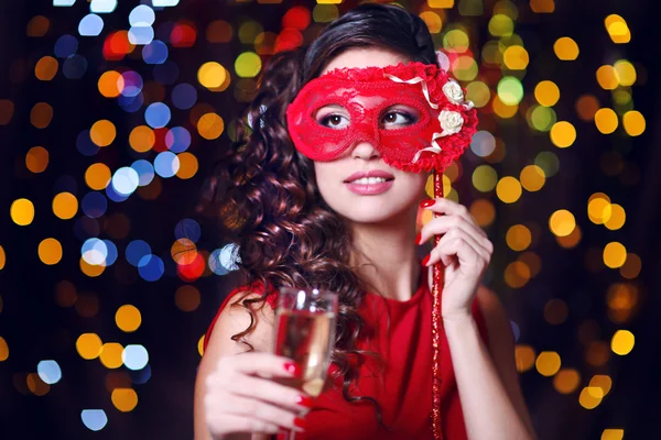 Krásná dívka s maškarní masku a šampaňské na světlé pozadí — Stock fotografie
