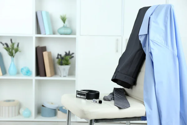 Ropa de hombre en silla con estante sobre fondo — Foto de Stock