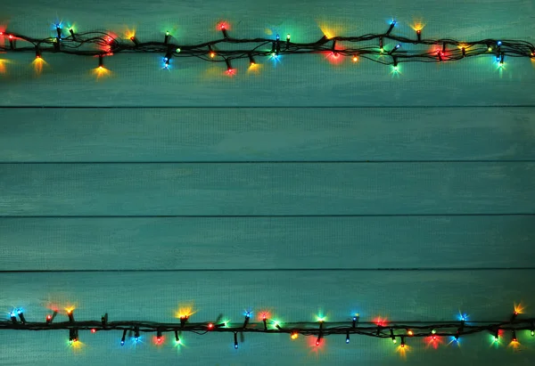 Ahşap plakalar arka plan üzerinde renkli Noel ışıkları