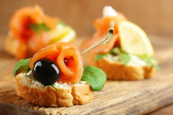 Canapés com salmão e azeitona preta — Fotografia de Stock