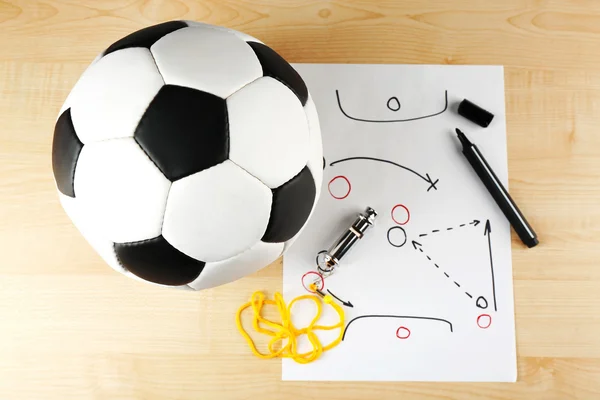 Esquema de juego de fútbol en hoja de papel y fondo de mesa de madera — Foto de Stock