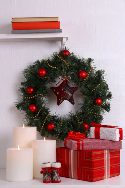 Christmas decoration with wreath on shelf on white wall background — Stock Photo, Image