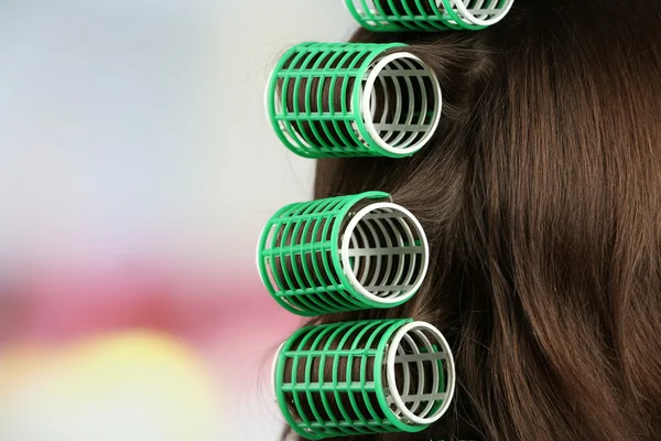 Cabello largo femenino durante el peinado con rizador, primer plano, sobre fondo claro — Foto de Stock