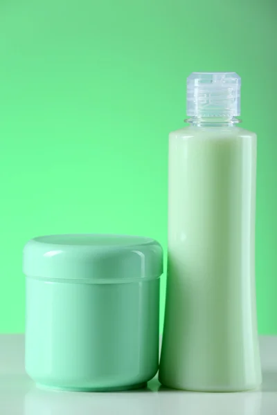 Botellas cosméticas sobre fondo verde claro —  Fotos de Stock