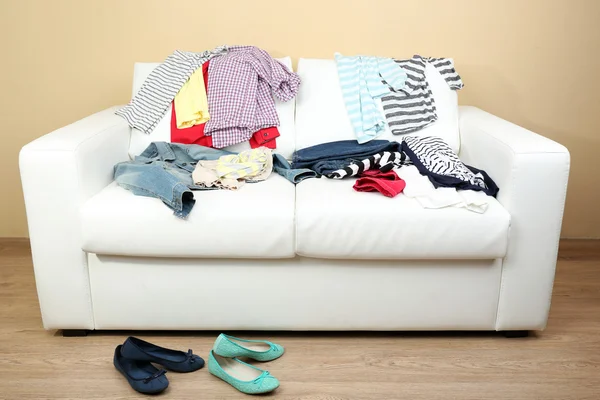 Ropa colorida en sofá blanco y zapatos femeninos —  Fotos de Stock