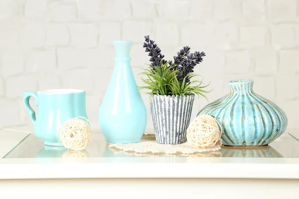 Interior com vasos decorativos e planta na parte superior da mesa e parede de tijolo branco fundo — Fotografia de Stock