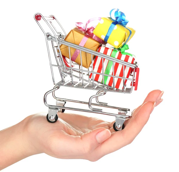 Vrouwelijke hand met kleine winkelwagentje vol geschenken, geïsoleerd op wit — Stockfoto